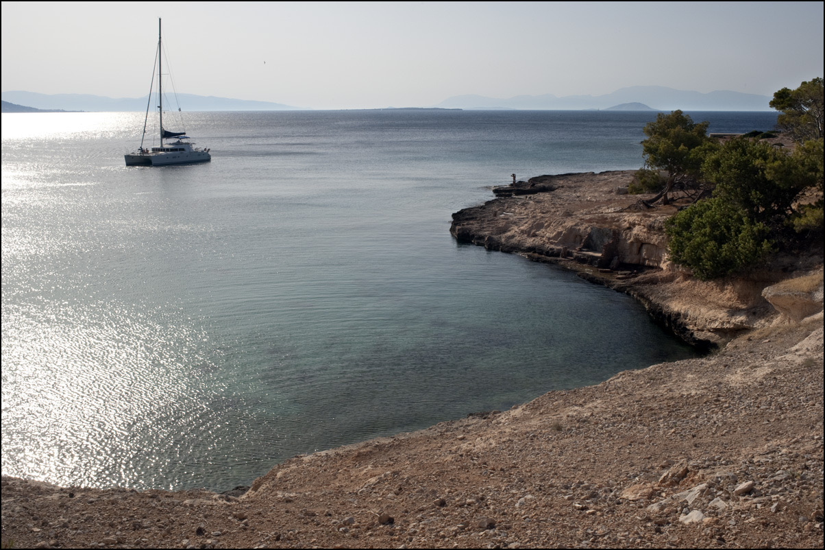 The pine-clad islet of Moni, its coves edged with green.