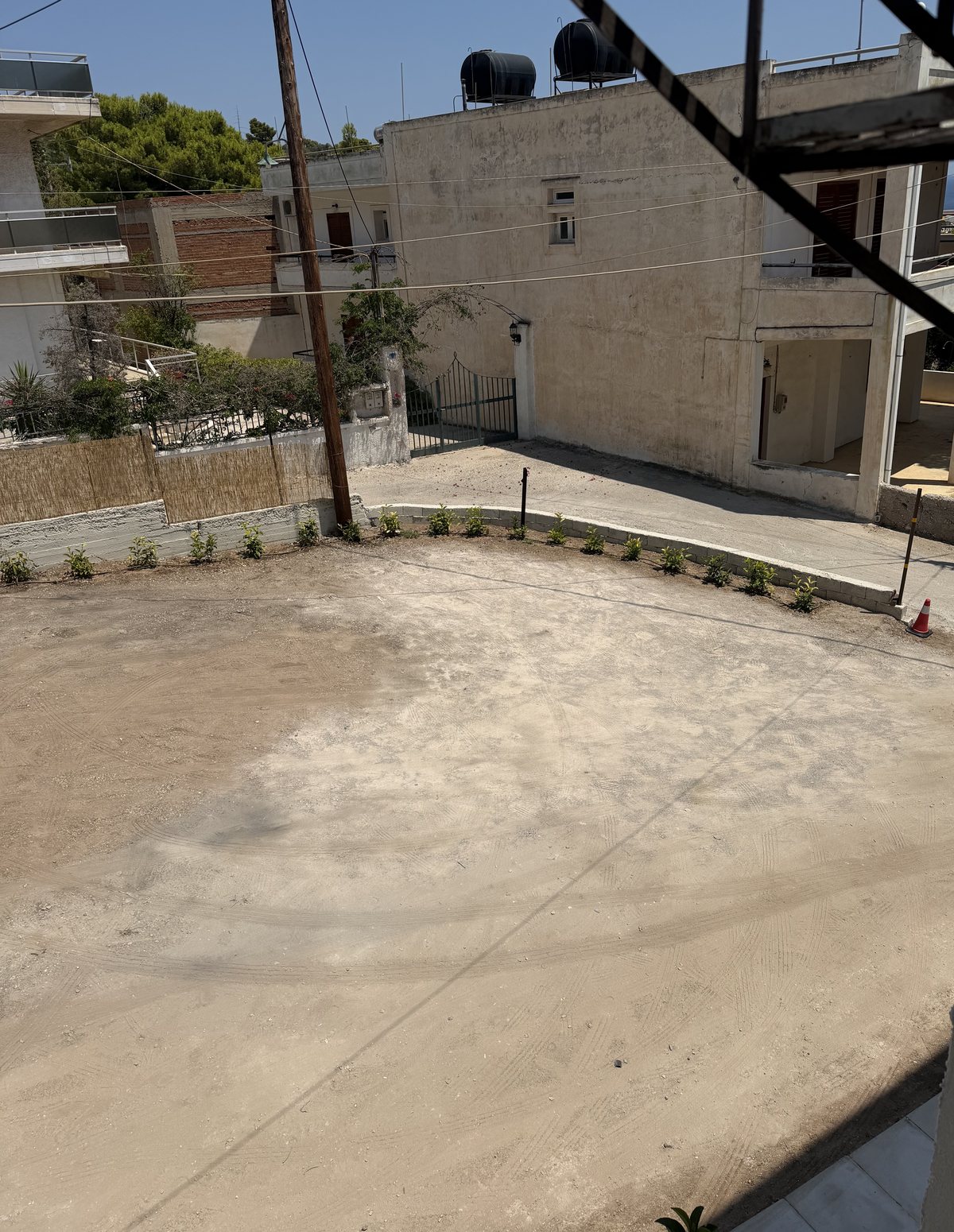 The P1 parking area beside Phi: an open gravel yard next to the hotel building, off Agiou Mina.